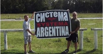 People hold a poster “Systema Argentina” People hold a poster “Systema Argentina”
