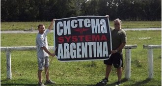 People hold a poster “Systema Argentina”